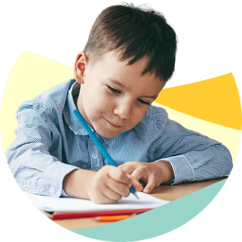 Young boy focused on writing at a desk